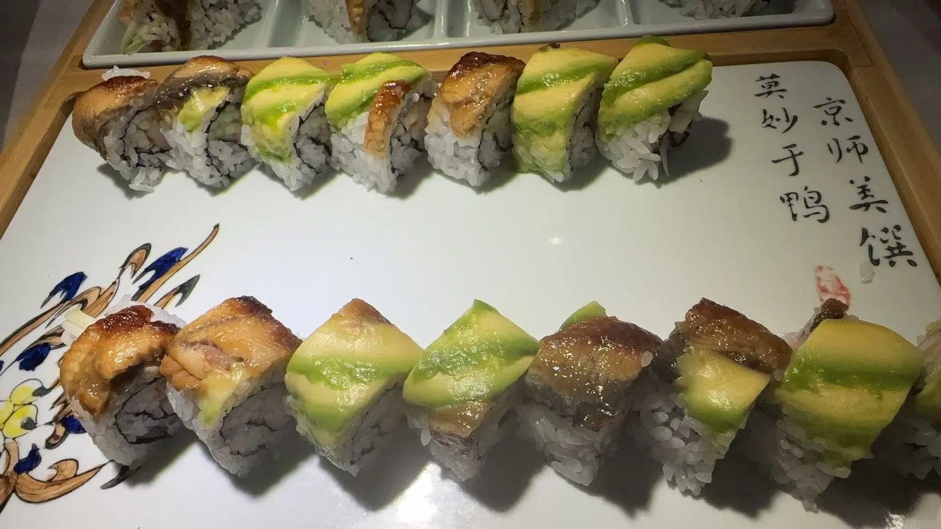 Two rows of eel avocado sushi rolls arranged on decorated ceramic plate at Sakura Buffet Restaurant in Pittsfield