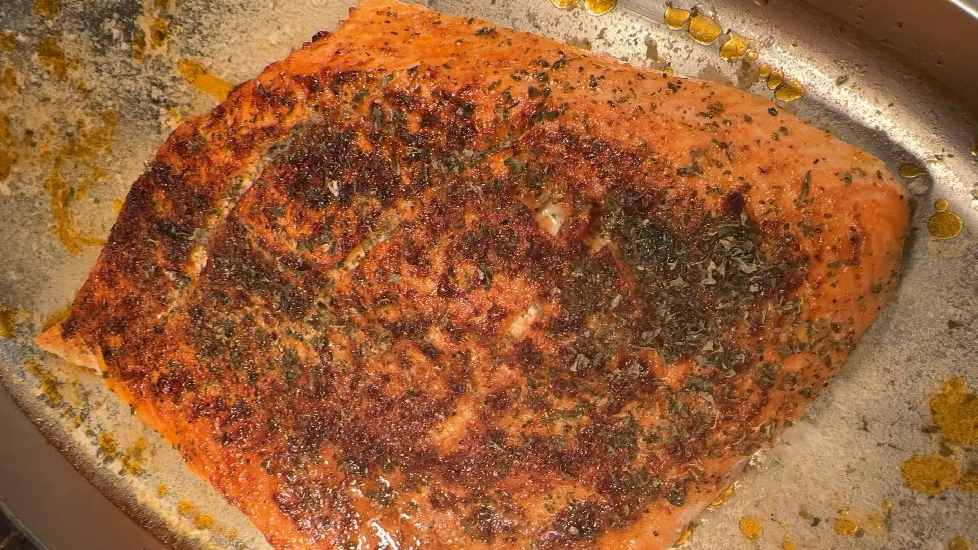 Seasoned baked salmon fillet sprinkled with dried herb flakes on metal pan at Sakura Buffet Restaurant in Pittsfield