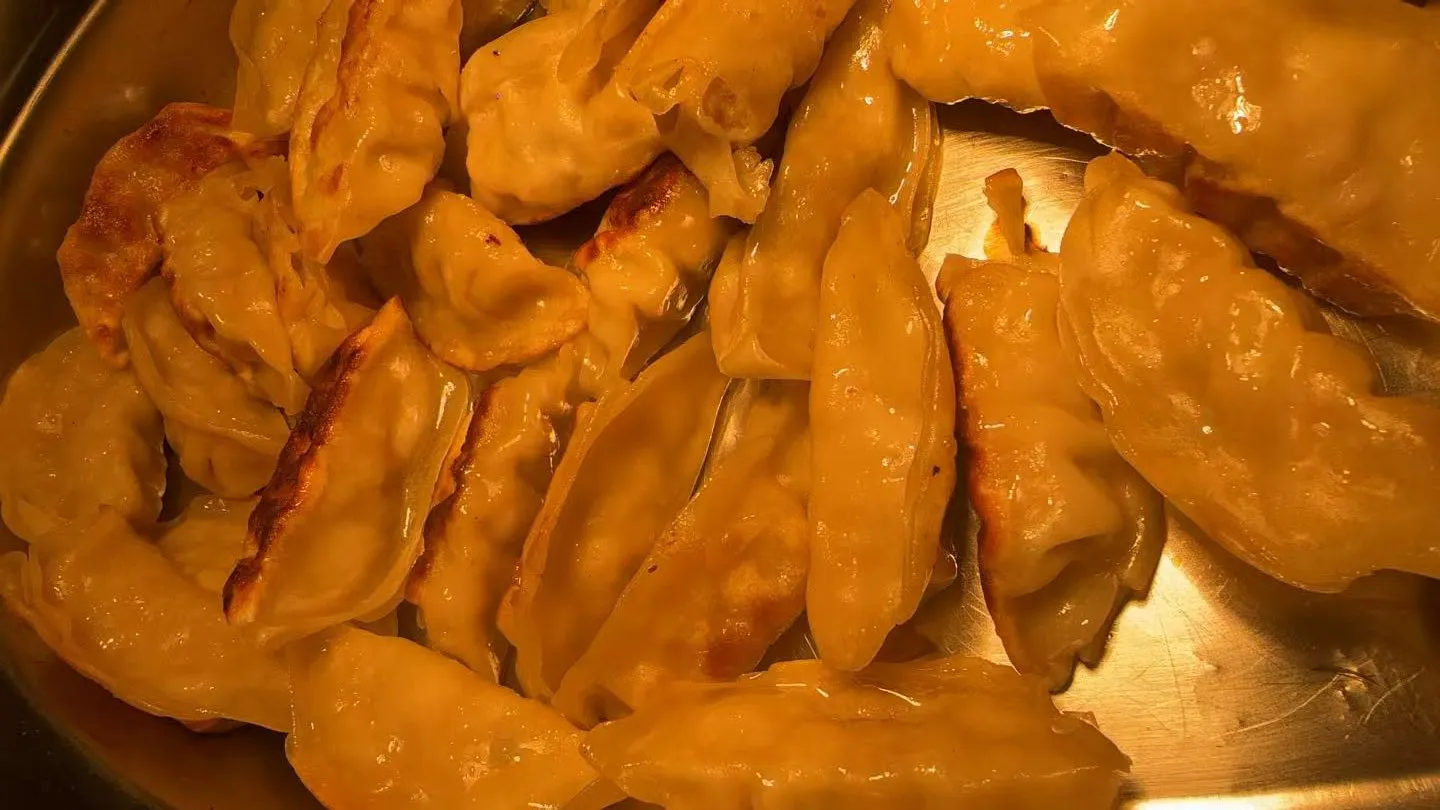 Pan fried golden dumplings stacked together on a metal tray at Sakura Buffet Restaurant in Pittsfield