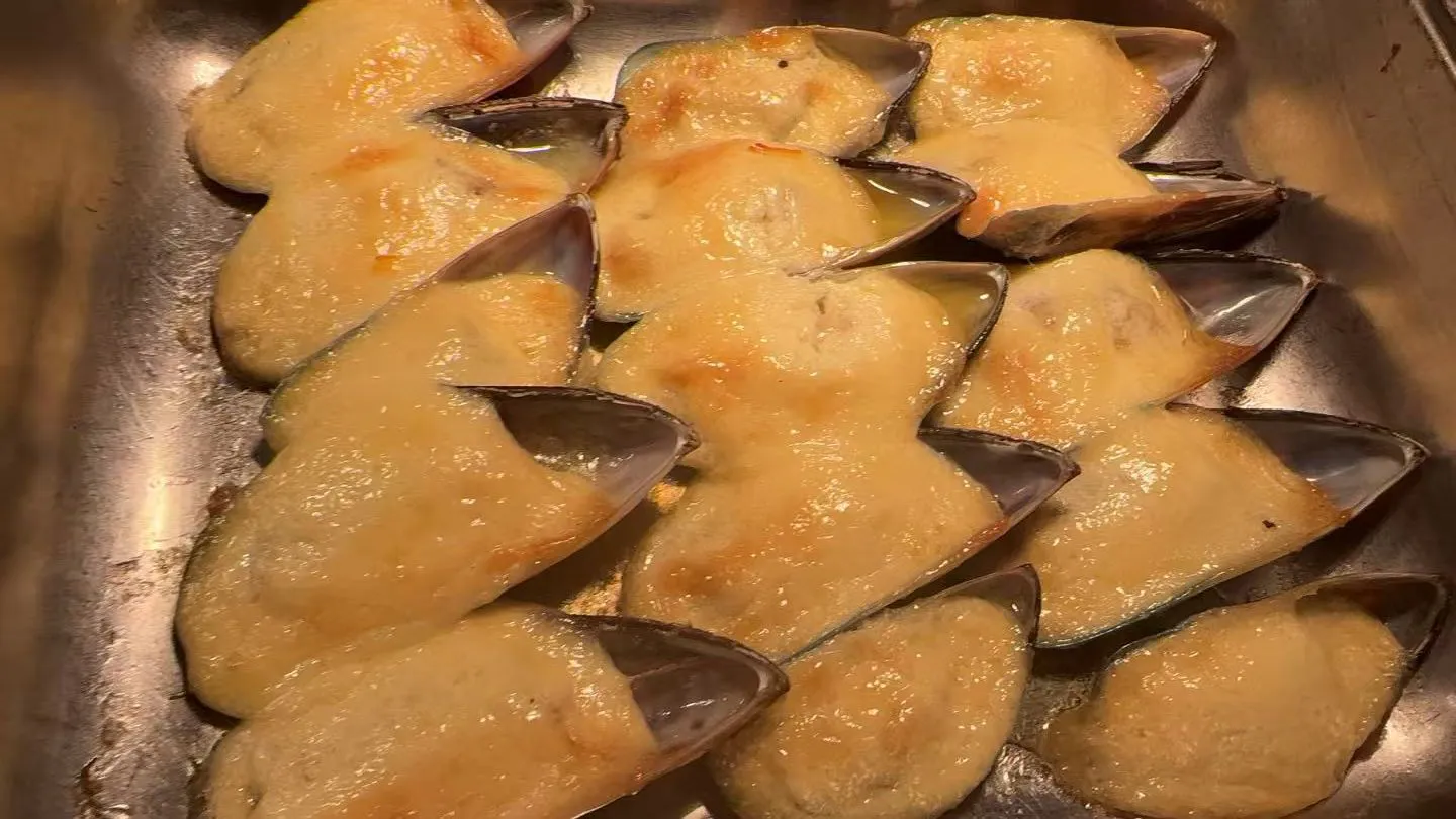 Baked mussels covered with creamy melted cheese on metal tray at Sakura Buffet Restaurant in Pittsfield