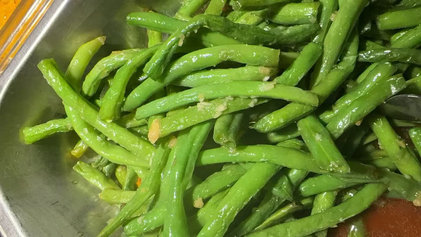 Garlic seasoned stir-fried green beans in a metal serving tray at Sakura Buffet Restaurant in Pittsfield